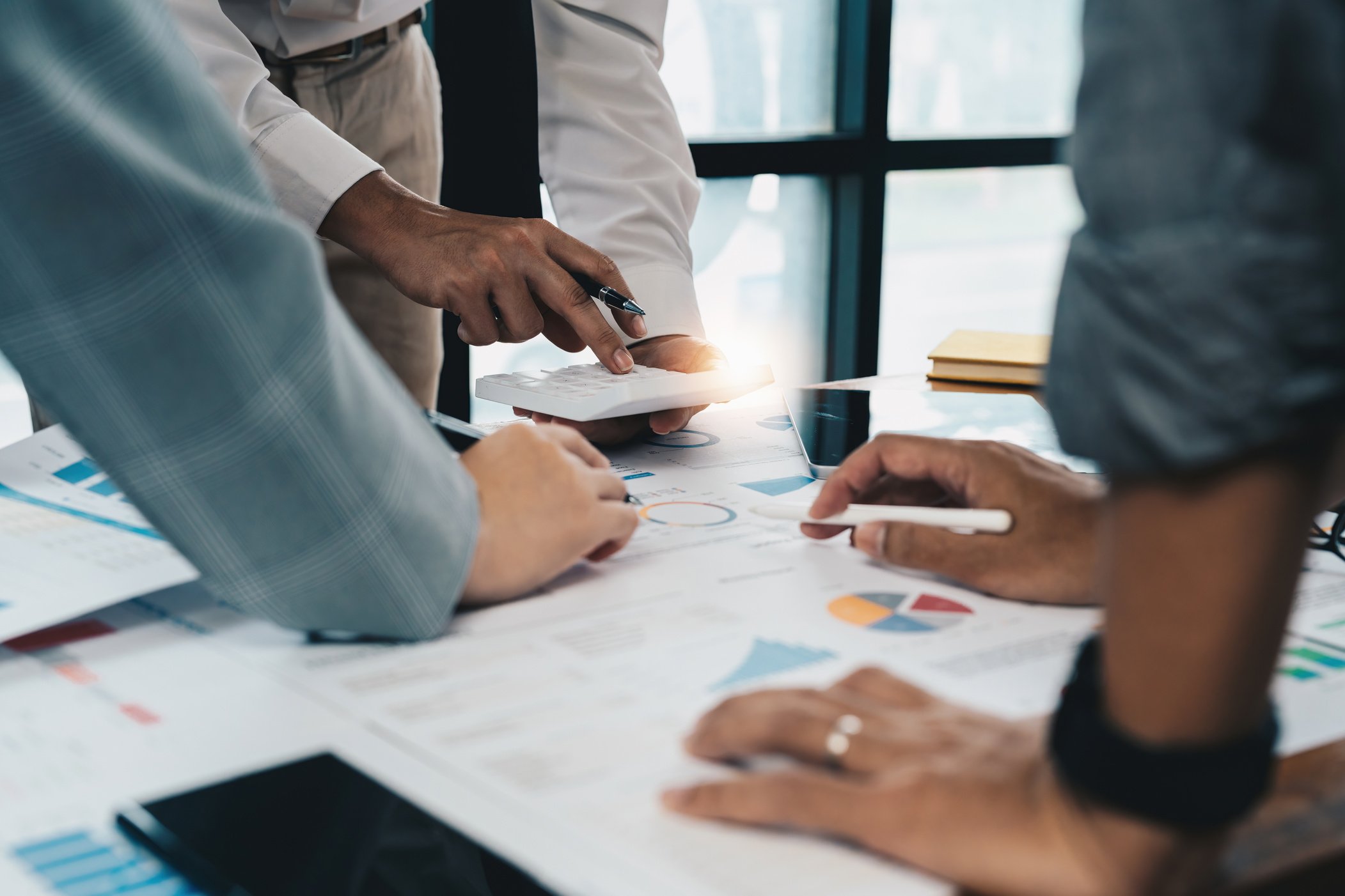 a group of business people are looking at papers on a table